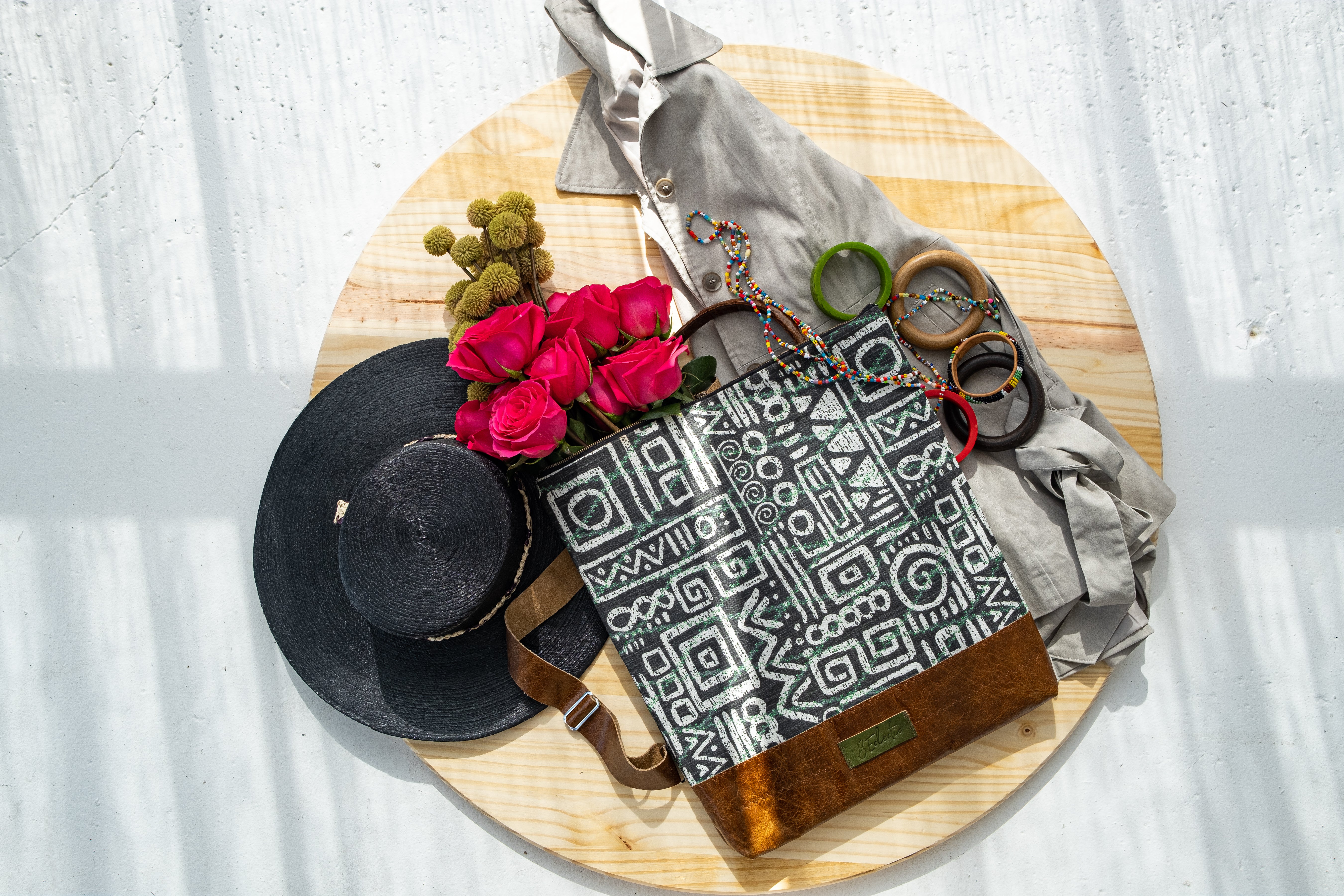 Flatlay of B.Eclectic Printed Backpack with shirt and black hat