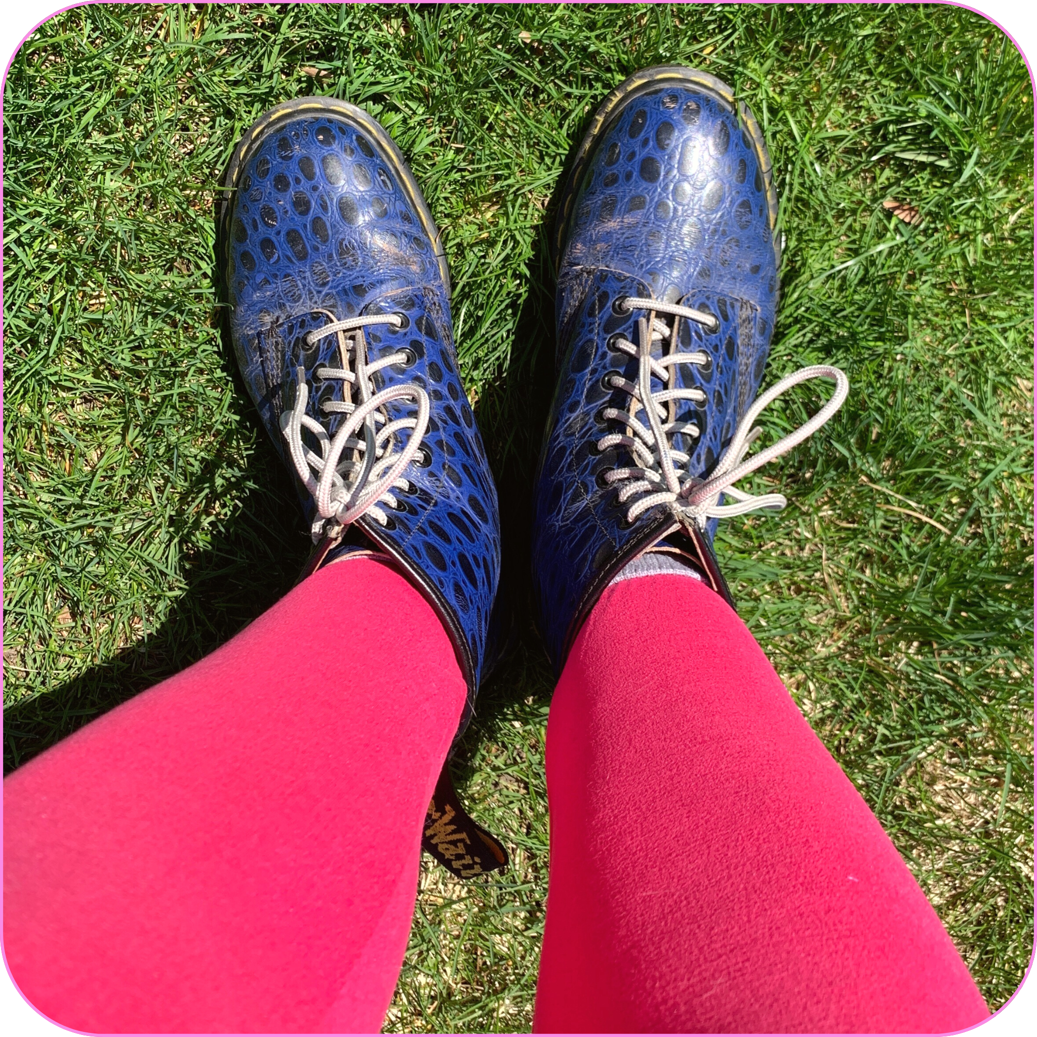 top view of feet wearing vintage blue crocodile print Doc Marten boots with bright pink leggings