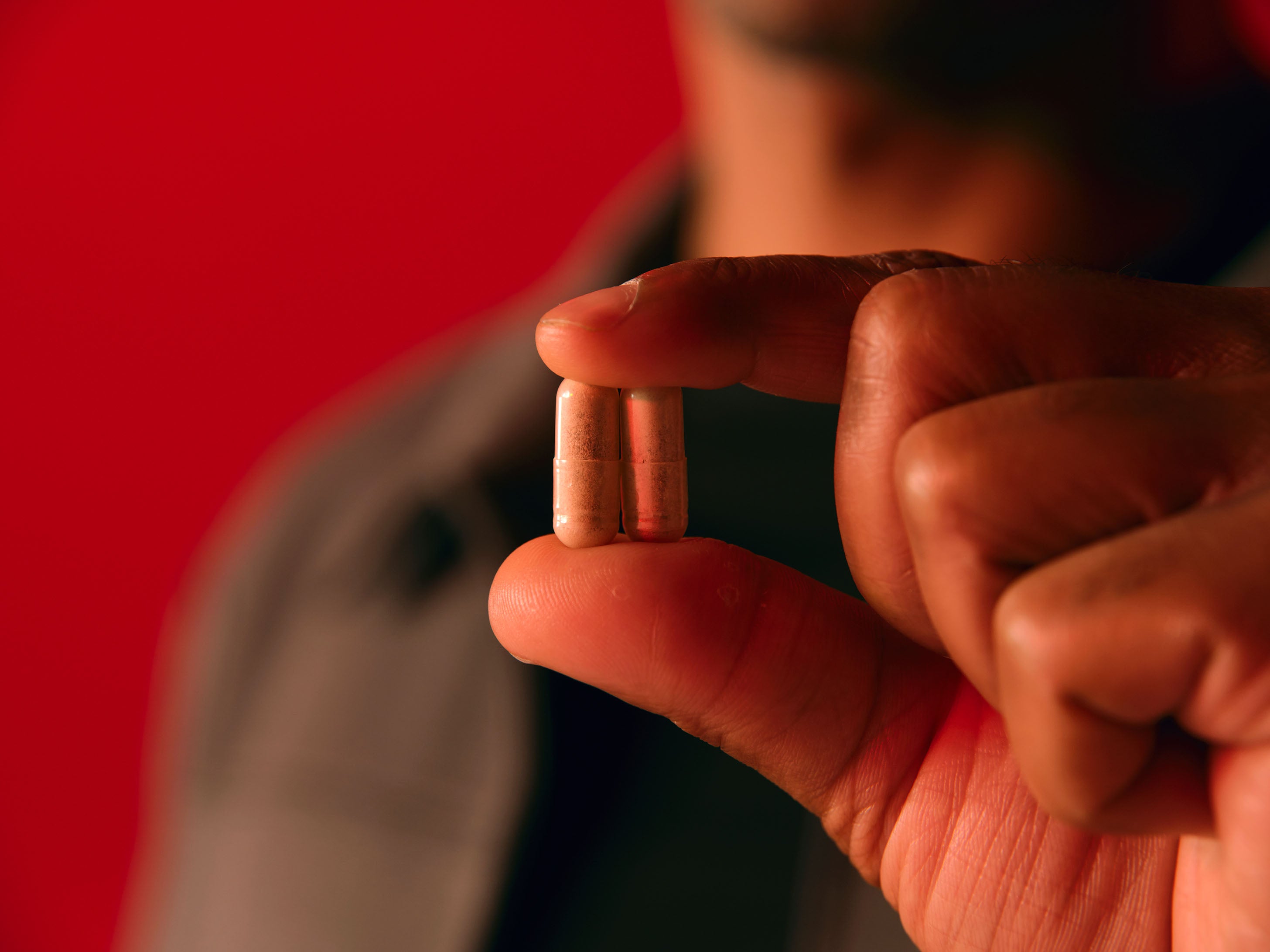 Man holding two Boost & Burn capsules up.