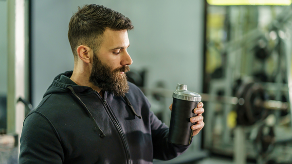 Man at gym looking at shaker cup