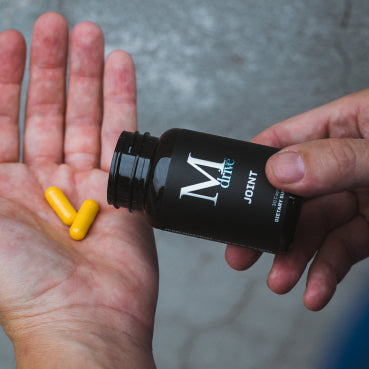 Man pouring M Drive Joint capsules into his hand