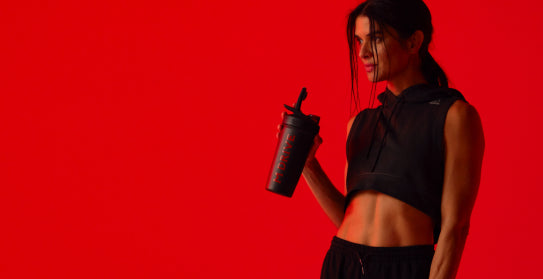 M Drive woman in crop top holding a shaker bottle
