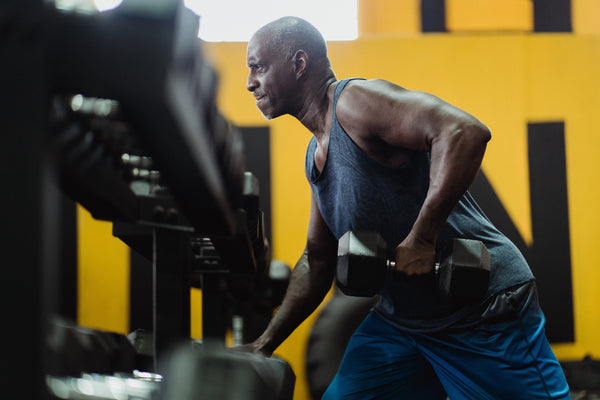 Bald man lifting weights at gym