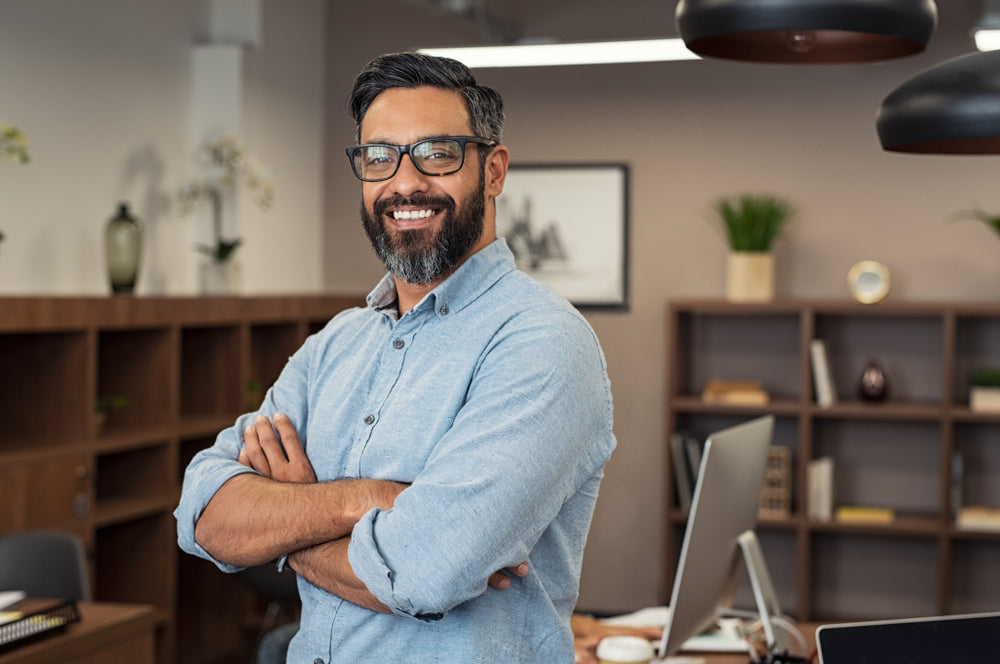 man smiling in office with arms crossed