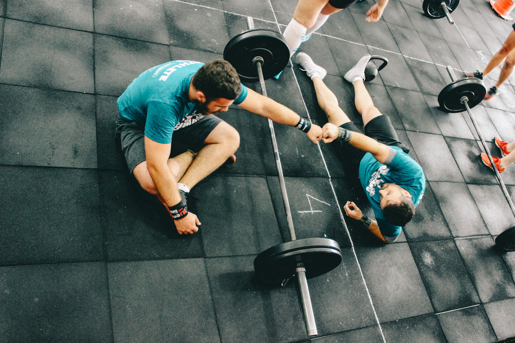 Two men fist bumping after a workout