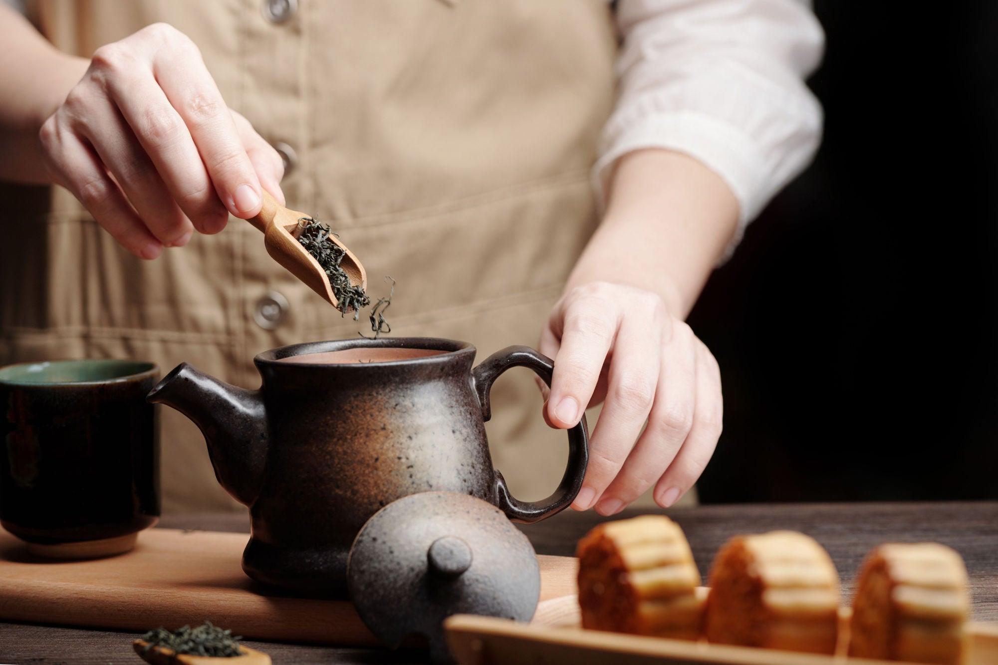 person preparing hot tea in metal teapot