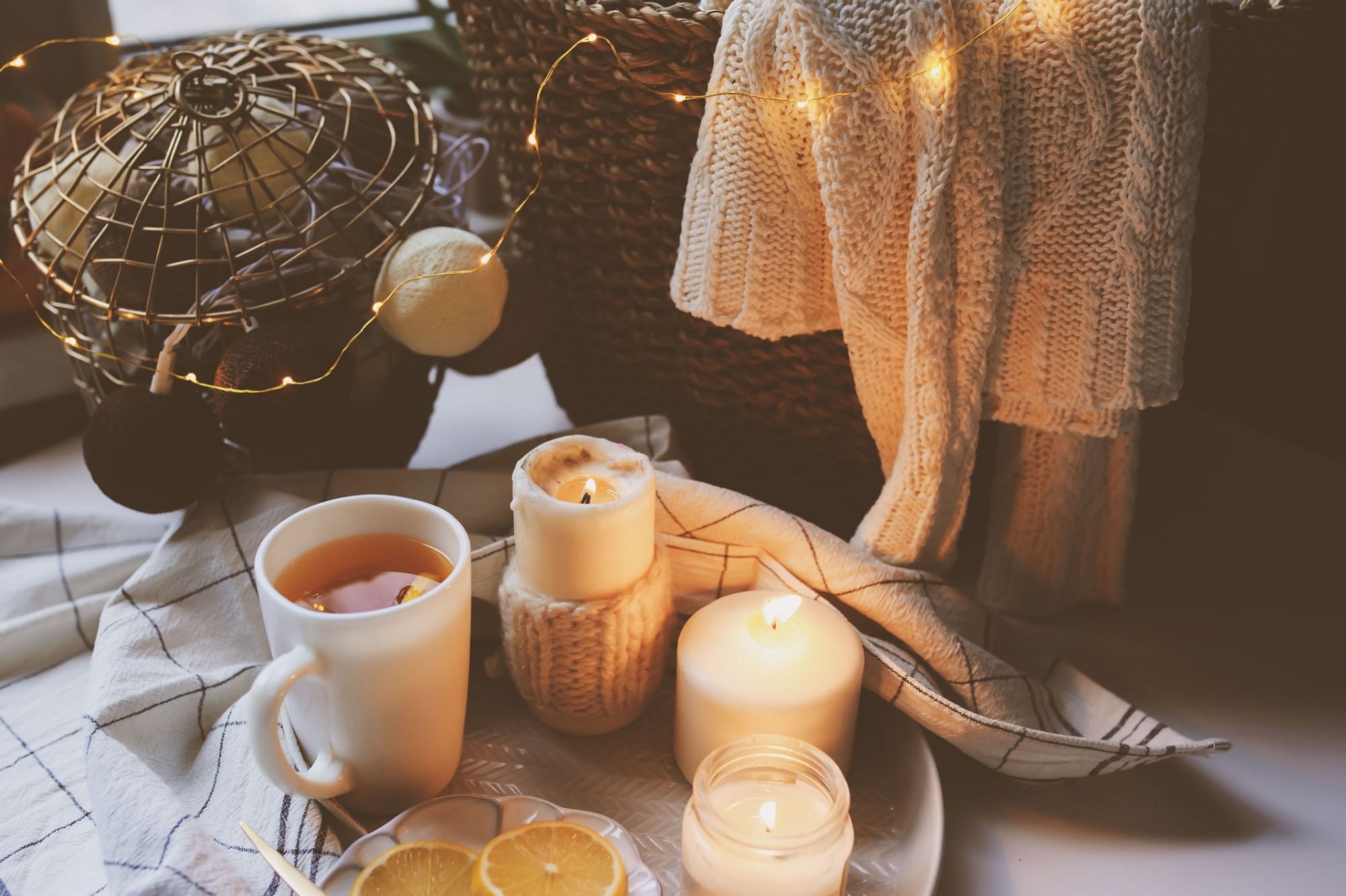 warm and cozy scene with coffee, candle, blankets