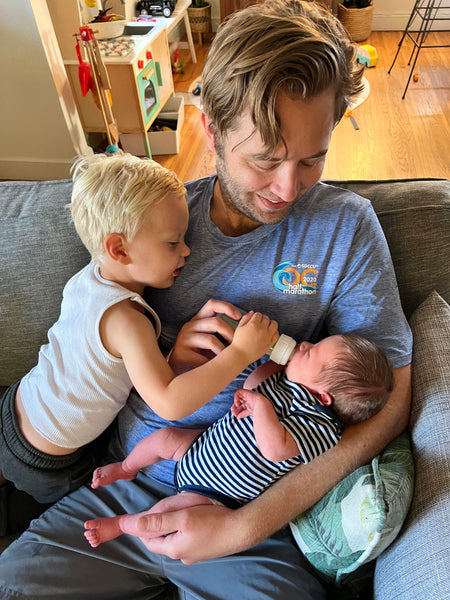 Man and toddler feeding infant