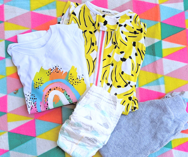 milimili banana sleep sack with rainbow tshirt, diapers and gray pants on rainbow blanket