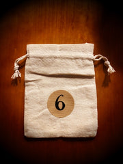 Fabric pouch numbered with the number 6 handwritten on a sticker