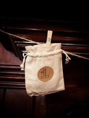Fabric pouch numbered with a handwritten number 1 and hung onto the string with a peg