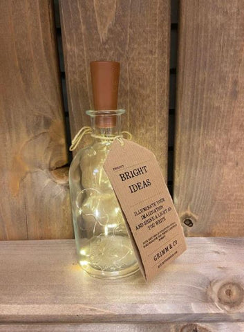 Image showing a glass bottle with cork-style lid attached to a string of lit LED fairy lights. Label says Bright Ideas.