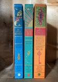 Image of the three MinaLima clothbound interactive classic books stood with spines facing out. 