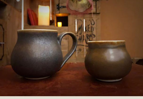 Image shows both sizes of Travel Cauldron in regular mug size (with a handle) and small like an espresso cup.