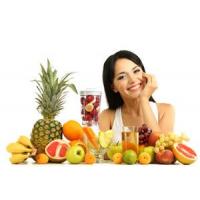 A person sitting behind a table full of fruits