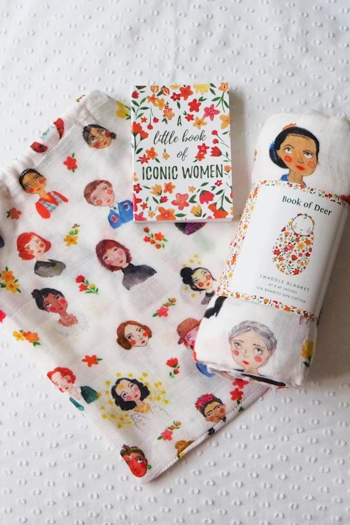 Snuggle blanket for baby girls with iconic females illustrated on it.