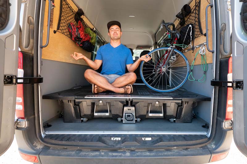 Sergei Boutenko sitting on custom van shelving build