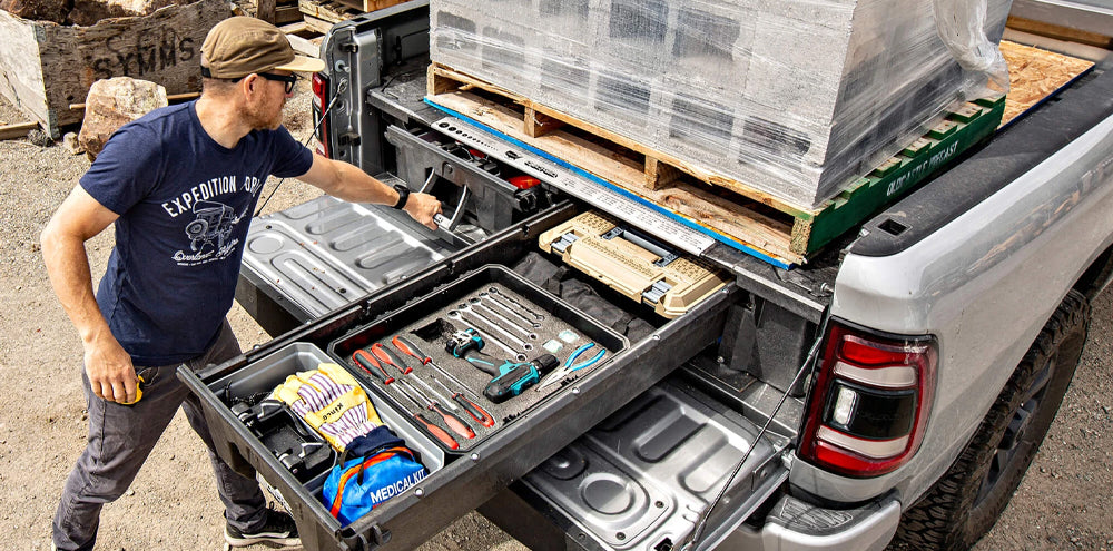 Man using DECKED sliding drawer system to safely store construction tools