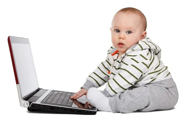 Baby boy sitting in front of computer