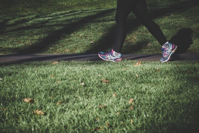 A women in sports attire running in a park