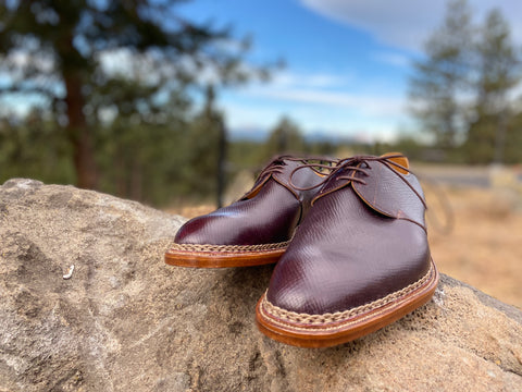 Pure Polish RAB Bespoke Oxblood Russian Hatch Grain Derbies on a rock with trees both shoes facing forward