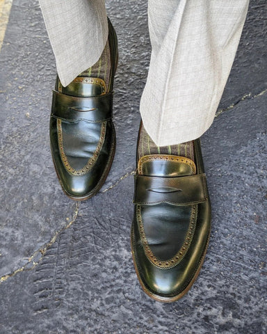 Man in tan slacks wears custom green patina Crockett and Jones penny loafers with green striped socks