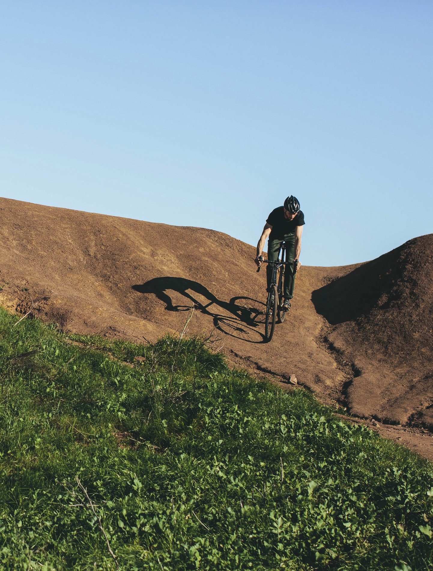 Our friend Jimmy riding down a dirt path on his bicycle. He's wearing the new CIVIC collection.