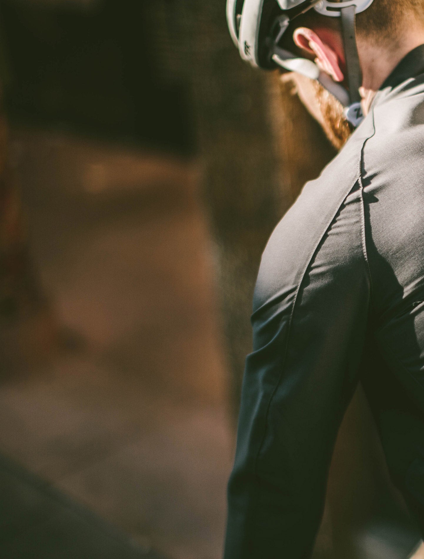 A shot of the back of a man riding a bicycle. He's wearing a piece of CIVIC outerwear.