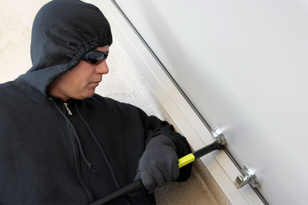 Man breaking into a door with a crowbar