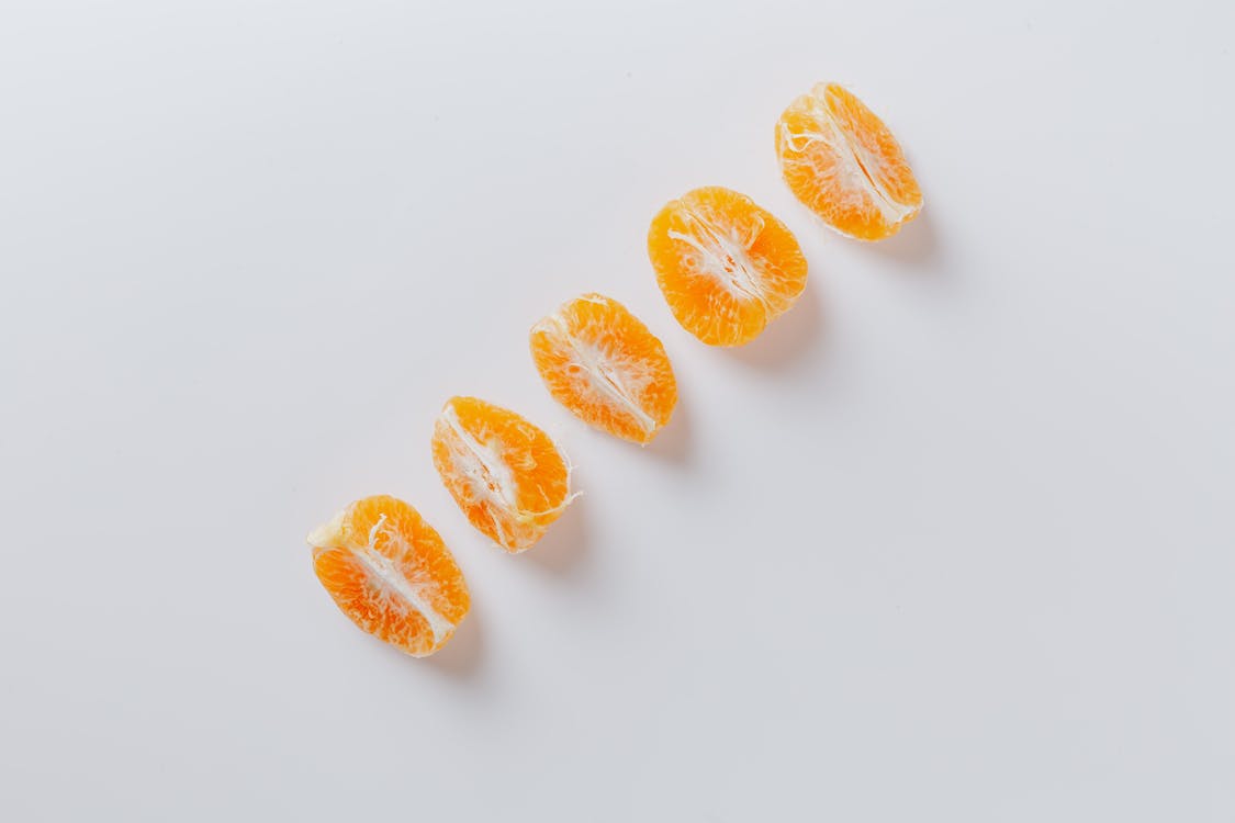 Fresh slices of mandarins arranged in row