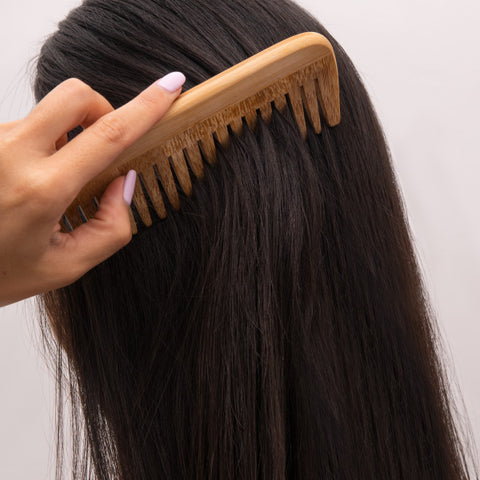 Femme brossant ses cheveux après les avoir lavés avec un shampoing adapté à son type de cheveux