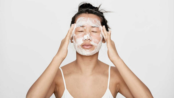 woman aplying a hydrating facemask on her face