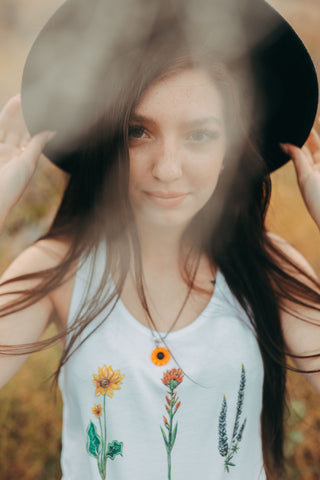 Graphic Style Tank top with Pacific Northwest Wildflowers on the front. Cute Wide Brim Hat. Field. Summer time. Golden Hour. Wearing white tank tops with jeans and jeans shorts. Summer time. Wenatchee, Washington. PNW Style. Pacific Northwest. Mountains. Mountain Style.