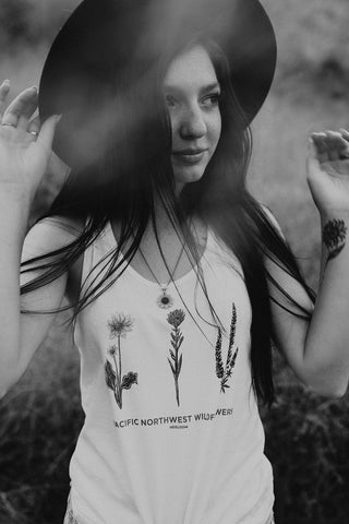 Graphic Style Tank top with Pacific Northwest Wildflowers on the front. Cute Wide Brim Hat. Field. Summer time. Golden Hour. Wearing white tank tops with jeans and jeans shorts. Summer time. Wenatchee, Washington. PNW Style. Pacific Northwest. Mountains. Mountain Style.