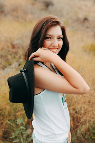 Graphic Style Tank top with Pacific Northwest Wildflowers on the front. Cute Wide Brim Hat. Field. Summer time. Golden Hour. Wearing white tank tops with jeans and jeans shorts. Summer time. Wenatchee, Washington. PNW Style. Pacific Northwest. Mountains. Mountain Style.