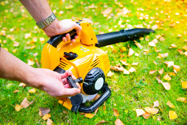 Starting a handheld, cordless leaf blower to clean a lawn. Schröder USA