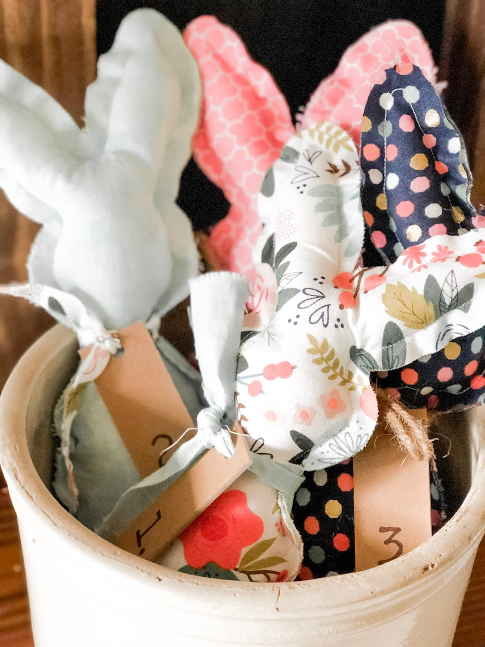 Fabric bunnies that are finished and sitting in an old crock