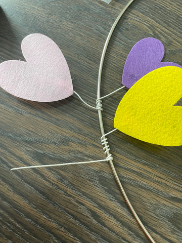 wrapping the wire around the circle to create a "v" shape and have points on the left and right to attach the hearts