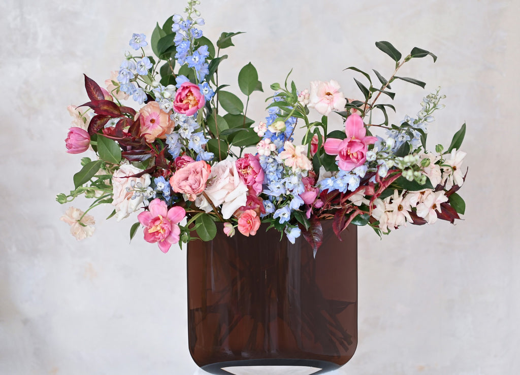 The bouquet of flowers filled with ink and blue flowers, presented in the caramel NUDE Blade vase