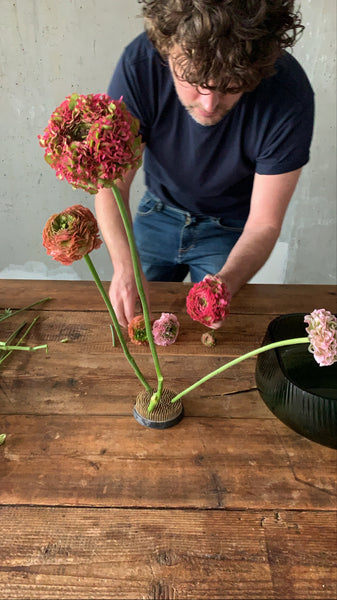 @the_ikebana_project placing the final flowers on the kenzan for the Ikebana creation for NUDE in its Opti Collection