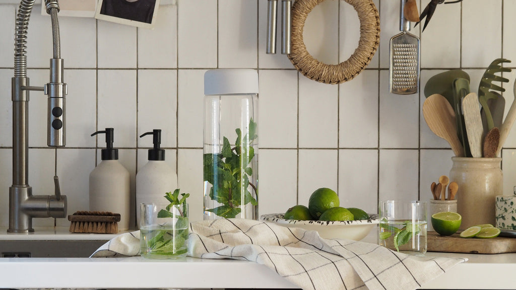 kitchen scenary with chrome tab, white tiles, presented with NUDE Finesse glass jug and glasses