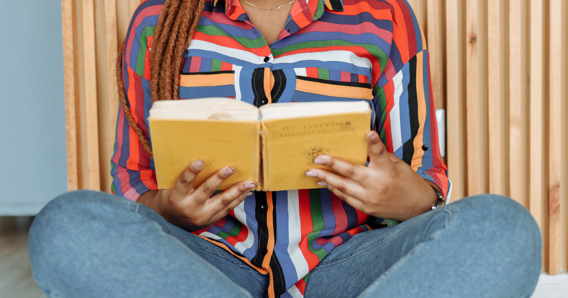 A woman sits cross legged reading a book