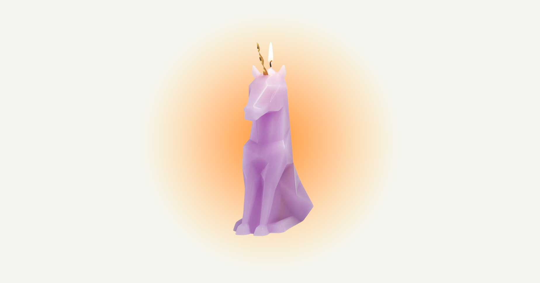 Purple candle in the shape of a unicorn with flame burning