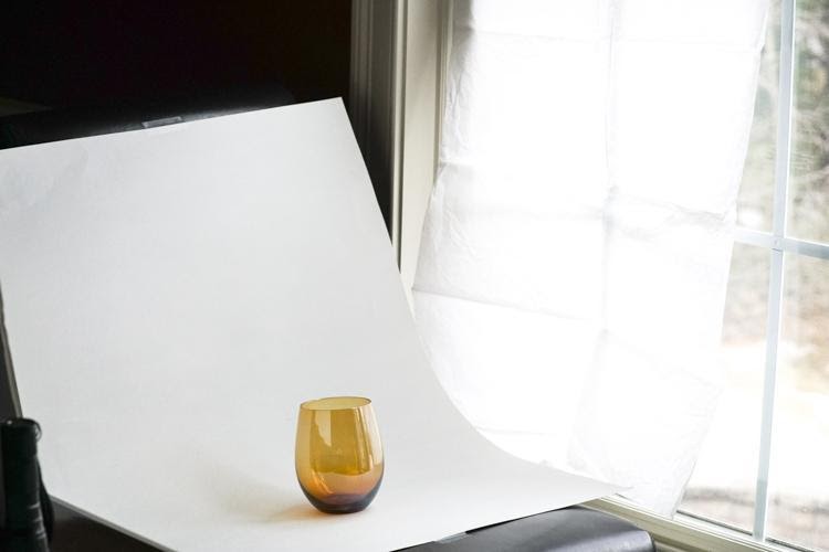 Photo d'un verre ambré sur un balayage blanc près d'une fenêtre