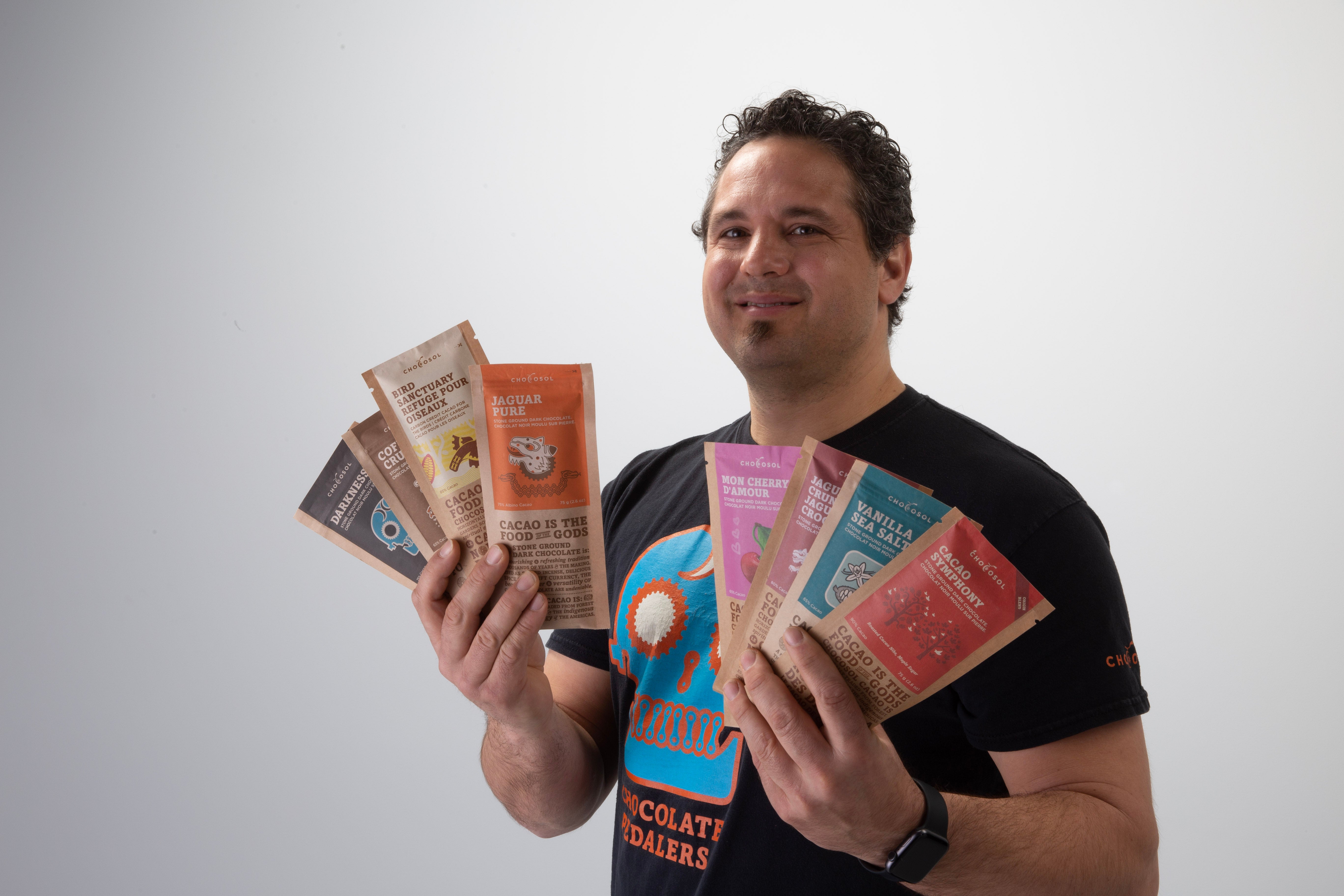 Michael Sacco, the founder of ChocoSol, holding their complete products.