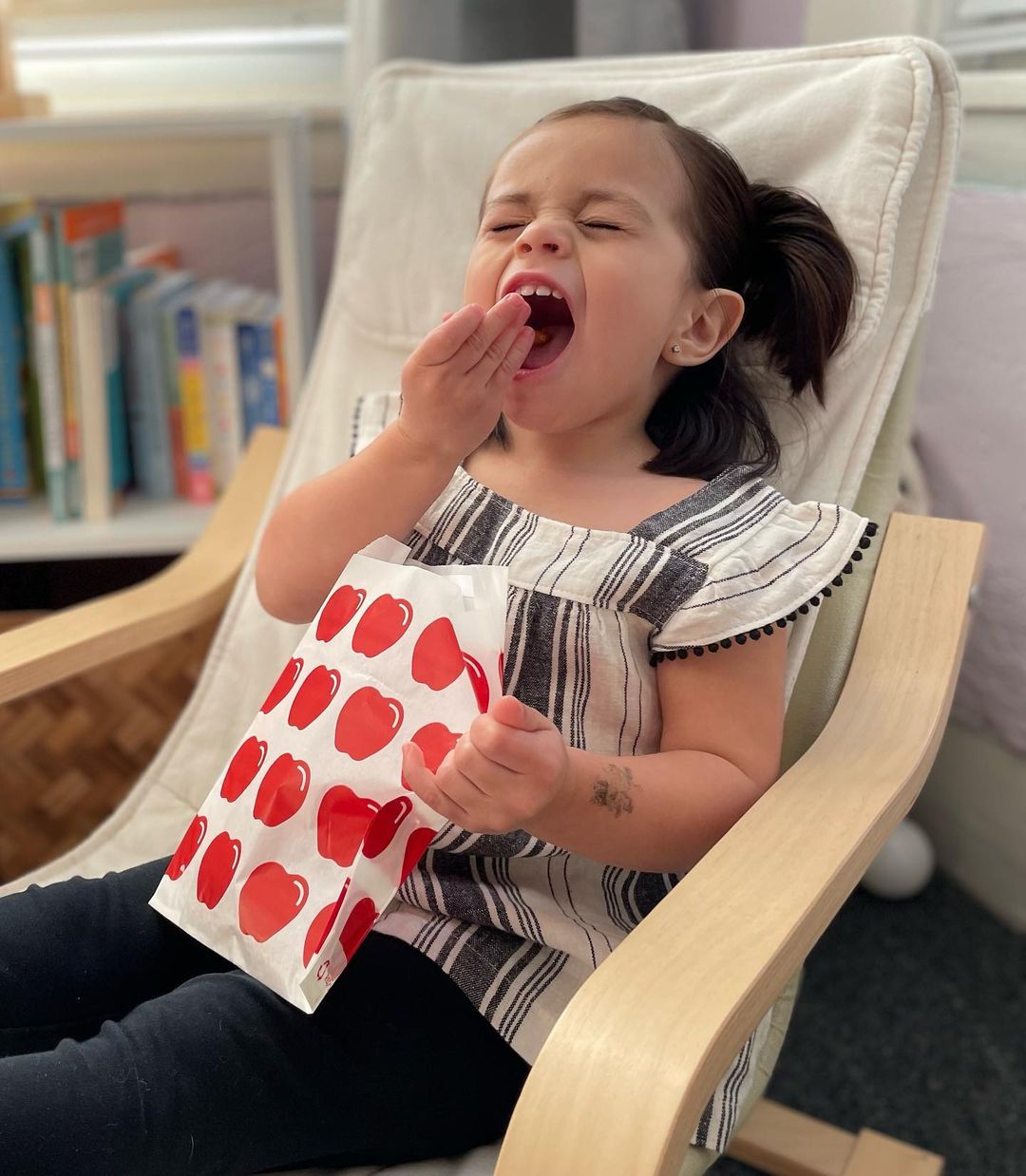 A child enjoying her snack out of a compostable Lunchskins snack bag.