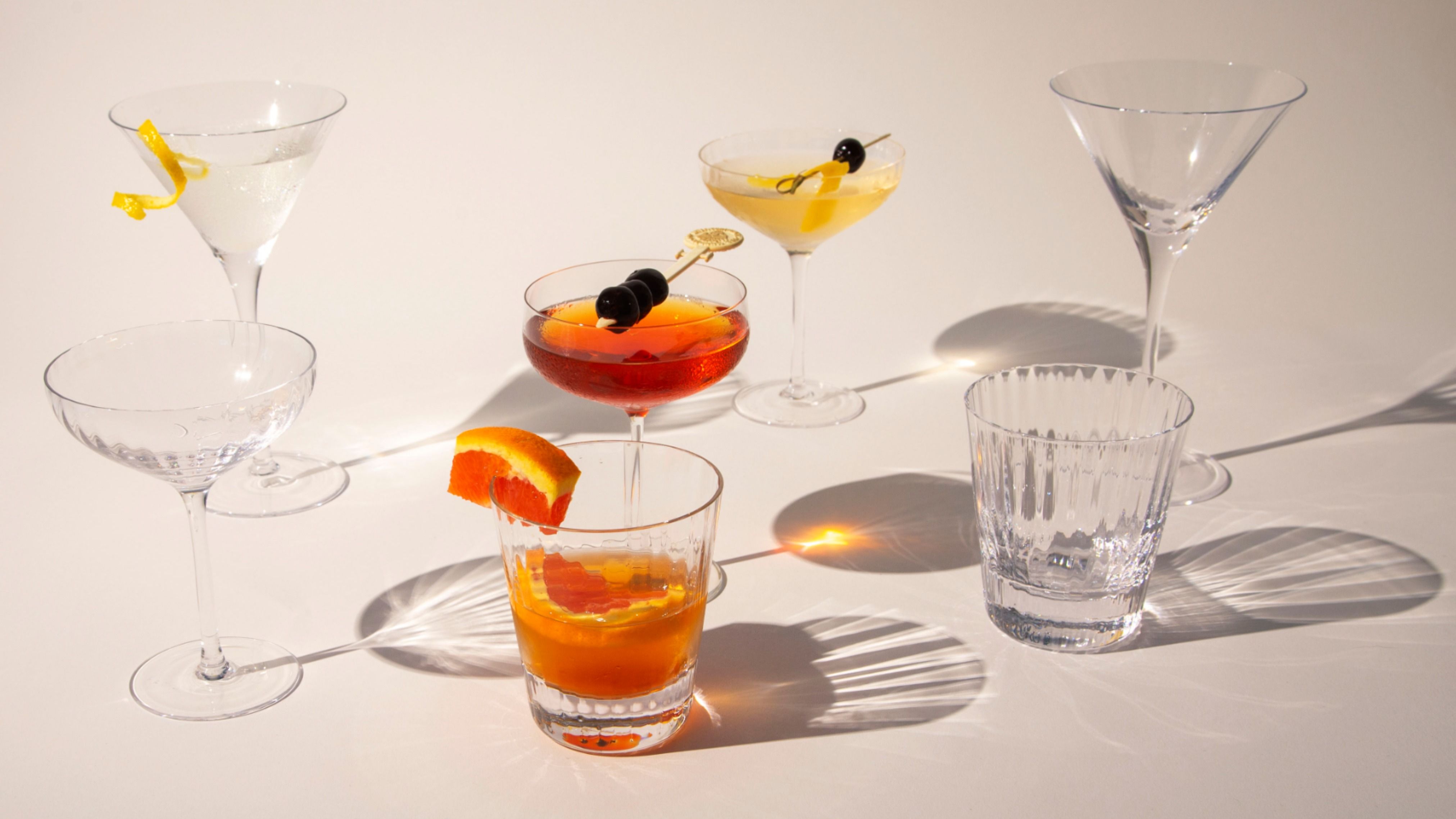 A collection of mid century cocktail classes displayed on an off-white background.