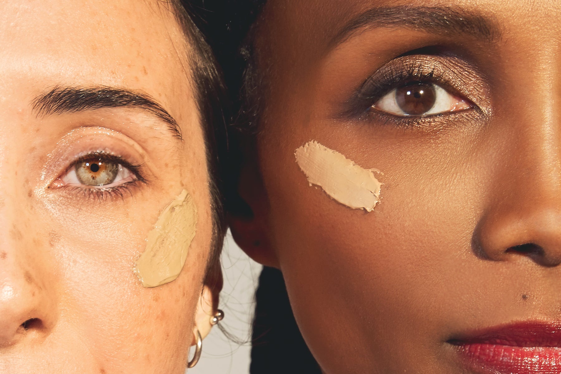 Two models’ eyes, side by side, with Unsun Cosmetics’ tinted sunscreen on their cheeks. 