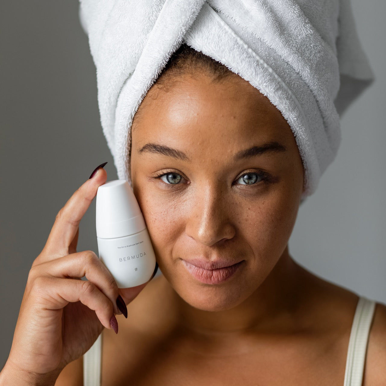 A model holds up a bottle of the body oil from Bushbalm.