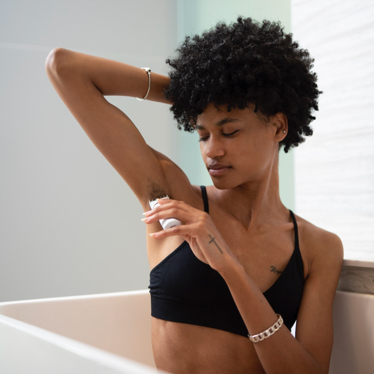 A model in a bathtub setting using a trimmer by Bushbalm.